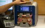 Un employé compte des liasses de dinars irakiens, le 8 décembre 2023 à Bassora, la grande ville du sud de l'Irak