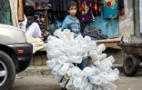 Un enfant yéménite récupère des bouteilles d'eau en plastique, le 24 janvier 2017 à Sanaa