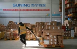 Un employĂ© transfère des colis Ă livrer Ă l’entrepĂ´t de Suning Logistics Network, Ă Shenyang en Chine, le 11 novembre 2020