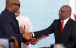 Le chef de la délégation congolaise Sumbu Sita Mambu (G) serre la main du secrétaire exécutif du groupe armé M23,  Benjamin Mbonimpa (D), après avoir signé une déclaration de principe comprenant un accord de cessez-le-feu, le 19 juillet 2025 à Doha