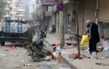 Un homme examine des cartons et des sacs dans une rue de la ville d'Afrine, reprise par les forces turques et leurs alliés rebelles syriens et où des pillages ont eu lieu, le 19 mars 2018