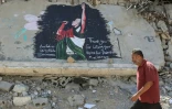 Un homme marche à proximité d'une fresque représentant l'artiste Macklemore, le 19 septembre 2026 à Gaza