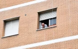 Un habitant de l'immeuble où un nouveau foyer de Covid-19 a été détecté, à la fenêtre de son appartement, le 13 juin 2020 à Rome