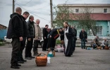 Prêtre bénissant des fidèles et leurs paniers de Pâques, lors de la Pâques orthodoxe, à Slovyansk, dans l'est de l'Ukraine, le 23 avril 2022