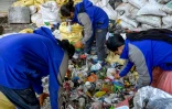 Des personnes trient les déchets récupérés sur les pentes de l'Everest pour les recycler à Katmandou, le 12 juin 2024 au Népal