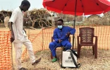 Un employé désinfecte les pieds d'un homme à l'entrée d'une unité d'isolement pour les malades du choléra, à Tawila dans l'ouest du Soudan le 12 août 2025