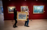 Des employés du Musée Marmottin transporte une peinture de Claude Monet le 18 mai 2021, la veille de la réouverture des terrasses et des lieux culturels 