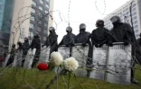 La police bélarusse se tient derrière des barbelés sur lesquels sont attachées des fleurs, durant une manifestation le 6 septembre 2020 à Minsk