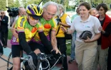 Le cycliste amateur français Robert Marchand (g), 100 ans, est aidé par son entraîneur Gérard Mistler (c), après avoir battu le record sur 100 km des plus de 100 ans, le 28 septembre 2012 au vélodrome de Lyon