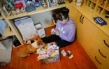 L'étudiante Wang Zhaoxue dans sa chambre, avec son chien, entourée de figurines de "blind box", le 13 avril 2021 à Pékin, en Chine