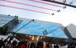 Les pilotes de la "Patrouille de France" survolent le Palais des Festivals à l'arrivée de Tom Cruise (c) et Jennifer Connelly pour la présentation du film "Top Gun: Maverick", le 18 mai 2022 à Cannes