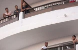 Des migrants au balcon d'un des complexes touristiques qui logent 5.500 migrants Ă Playa del Ingles, l'une des plages les plus connues des Canaries, le 22 novembre 2020