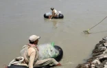 Sur des chambres à air gonflés des pêcheurs pakistanais sont à la recherche de poissons dans la rivière Kaboul, à Hajji Zai, village du nord-ouest du Pakistan