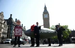 Un manifestant déguisé en Premier ministre britannique Keir Starmer pose devant une réplique d'une bombe et porte une pancarte indiquant "plus de 52.000 personnes tuées", près du palais de Westminster à Londres, le 12 mai 2025