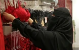 Une vendeuse arrange sur des portants des soutiens-gorge de couleur rouge dans une boutique à Ryad, le 9 février 2022 en Arabie saoudite