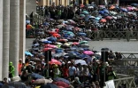 Les gens font la queue avec des parapluies sur la place Saint-Pierre pour accéder à la basilique où est exposé le corps du pape François, au Vatican, le 25 avril 2025