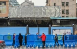 Des gardes installent des barrières devant le marché Huanan pendant une visite des experts de l'OMS, le 31 janvier 2021 à Wuhan, en Chine