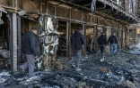 Des employés dans les décombres d'un centre commercial détruit par une attaque de drone à Odessa, le 21 mars 2025 en Ukraine