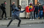 Un manifestant jette une pierre aux forces de police le 9 septembre 2020 à Bogota, secouée par des émeutes après la mort d'un homme victime de bavure policière
