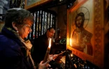 Des fidèles chrétiens allument des cierges autour du tombeau où le Christ a été enterré, dans l'église du Saint-Sépulcre à Jérusalem, le 21 mars 2017