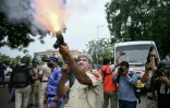 Un policier tire des grenades lacrymogènes pour disperser des militants du "Parti du peuple des cafards" (CJP) lors d'une manifestation réclamant la démission du ministre de l'Éducation, Dharmendra Pradhan, en raison de fraudes présumées aux examens universitaires, le 20 juillet 2026 à New Delhi, en Inde