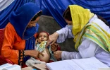 Une médecin (d) examine un enfant lors d'un programme de nutrition de l'Unicef au village de Fateh Muhammad Soomro, dans la province du Sindh, le 29 juillet 2025 au Pakistan