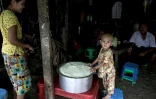 Un enfant devant une marmite de riz distribué par le PAM à Rangoun le 21 mai 2021