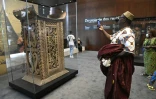 Un visiteur prend des photos du trône du roi Ghezo, l'un des objets pillés par les soldats coloniaux français, restitué et exposé à Cotonou, au Bénin, le 20 février 2022