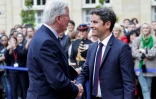 Michel Barnier sert la main du Premier ministre sortant Gabriel Attal lors de la cérémonie de passation de pouvoir à l'Hotel Matignon à Paris, le 5 septembre 2024 