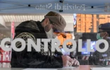 Un homme portant un masque remplit un formulaire à la gare Termini de Rome à côté d'une soldate portant elle aussi un masque, le 10 mars 2020.