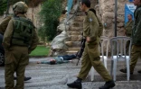 Des soldats israéliens, près du corps d'un Palestinien qui avait tenté de poignarder un soldat dans la colonie juive de Beit Hadassah, au centre d'Hébron, le 29 octobre 2015