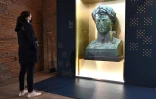 Une visiteuse admire un bronze "Buste de Napoléon 1er, empereur" du sculpteur italien Lorenzo Bartolini, lors de l'exposition "Napoléon et le mythe de Rome" au Musée des marchés de Trajan, le 11 mars 2021 à Rome