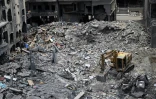Des ouvriers déblaient avec une pelleteuse les décombres d'un bâtiment par une précédente frappe militaire israélienne sur un quartier de Tyr, dans le sud du Liban, le 23 juin 2026