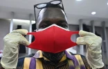 Roger Bango, créateur de mode et directeur de la société Korha, montre un masque fabriqué dans son atelier, le 9 avril 2020 à Abidjan, en Côte d'Ivoire