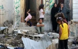 Des femmes et des enfants palestiniens au milieu des décombres d'une maison après une frappe israélienne sur le camp de Nousseirat, dans le centre de la bande de Gaza, le 27 septembre 2025 