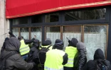 Des "gilets jaunes" s'attaquant à la vitrine du Fouquet's sur les Champs-Elysées, à Paris le 16 mars 2019 