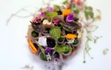 Une tartelette à l'aubergine décorée de fines fleurs colorées au menu du Pineapple and Pearls