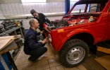 Sergueï Diogrik (g), responsable du Lada History Club, et son assistant Kamil restaurent une Lada Niva des années 1980, 4X4 de légende, dans leur garage à Togliatti, en Russie, le 31 mars 2022