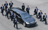 Des gardes du corps accompagnent en courant la voiture transportant le leader nord-coréen Kim Jong-Un après une session matinale de discussions au village de Panmunjom, le 27 avril 2018