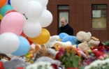 Le président russe Vladimir Poutine dépose des fleurs en hommage aux victimes d'un incendie dans un centre commercial, le 27 mars 2018 à Kemerovo, en Sibérie