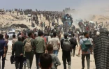Des Palestiniens à Jabalia dans le nord de la bande de Gaza se dirigent vers des camions transportant de l'aide humanitaire, le 22 juillet 2025