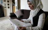 La réfugiée syrienne Ramia al-Sous montre des documents administratifs concernant sa famille dans son appartement dans la plaine de la Bekaa, au Liban, le 13 juin 2022