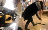 Une femme nettoie une boutique de souvenirs à Venise, affectée par un phénomène de montée des eaux ("acqua alta") historique, le 17 novembre 2019