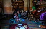 L'agricultrice Habiba (g) prend le petit déjeuner avec sa fille Zuheida (d) et sa petite-fille Saeeda dans le village d'Eshtiwi, au Nouristan, le 8 juin 2026 en Afghanistan
