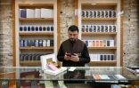 Un vendeur utilise un smartphone en attendant des clients dans un magasin à Kaboul, le 10 août 2026 en Afghanistan