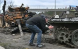 Un habitant de Bouzova, près de Kiev, prend en photo un tank russe détruit, le 10 avril 2022