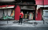 Un passant en prend photo la façade du restaurant "La Barrique" incendié et vandalisé près de la place de la République, au lendemain d'une manifestation contre la vie chère, le 18 octobre 2026 à Paris