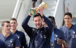 Le capitaine et gardien de l'équipe de France Hugo Lloris brandit la Coupe du monde, à l'arrivée à Roissy le 16 juillet 2018
