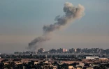 Une photo prise depuis Rafah, dans le sud de la bande de Gaza, montre de la fumée s'élevant au-dessus de bâtiments à Khan Younès après une frappe israélienne, le 4 février 2024