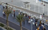 Des gens marchent près des fleurs et messages laissés à la mémoire des victimes à Nice le 20 juillet 2016
